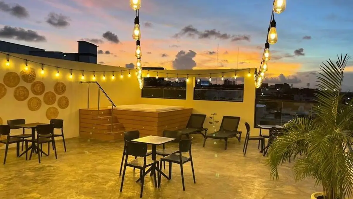 The rooftop terrace at Studio 27 at sunset, with tables and string lights